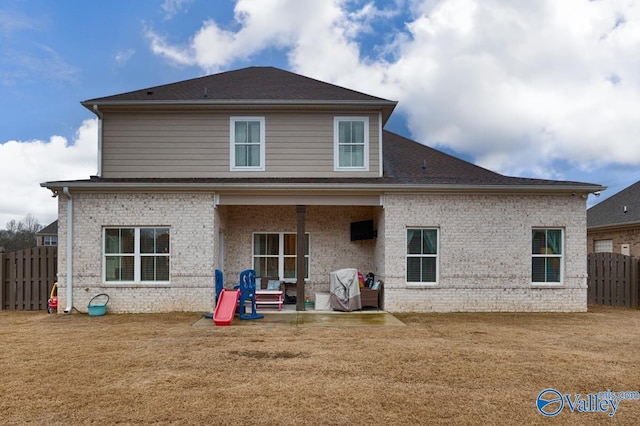 rear view of house with a patio and a lawn