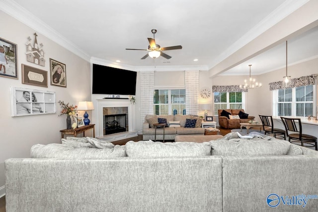 living room featuring hardwood / wood-style flooring, ceiling fan with notable chandelier, brick wall, and ornamental molding