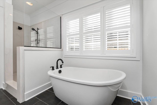 bathroom with a freestanding bath, tile patterned floors, a tile shower, and a healthy amount of sunlight