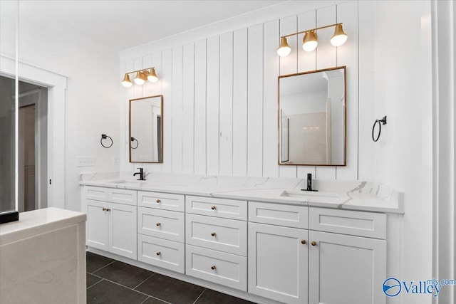 bathroom with crown molding, tile patterned flooring, a sink, and double vanity