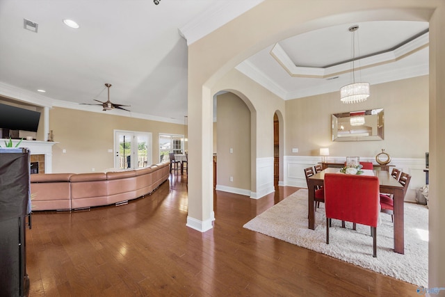 225 Nettles Dr NW, Madison, AL 35757 - dining room featuring a ceiling fan, a tile fireplace, crown molding, arched walkways, and wood finished floors