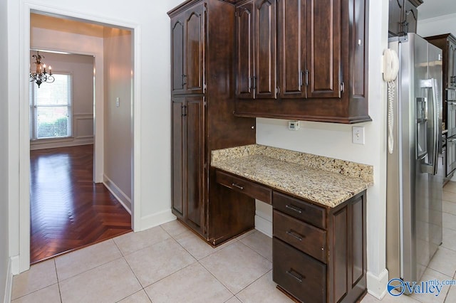 kitchen featuring a chandelier, dark brown cabinets, light stone countertops, light parquet flooring, and stainless steel fridge with ice dispenser