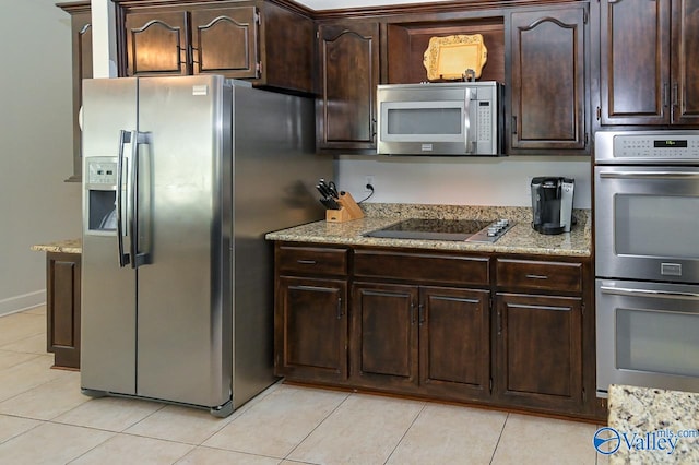 kitchen with light stone counters, appliances with stainless steel finishes, dark brown cabinetry, and light tile patterned floors