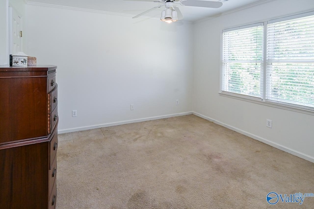 interior space with ceiling fan, crown molding, and light carpet