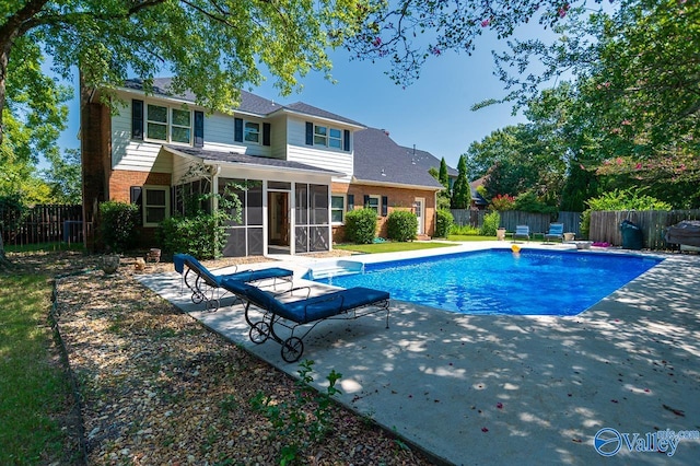 view of swimming pool featuring a sunroom and a patio