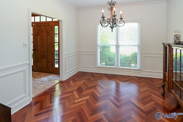 foyer featuring crown molding, a chandelier, and dark parquet flooring