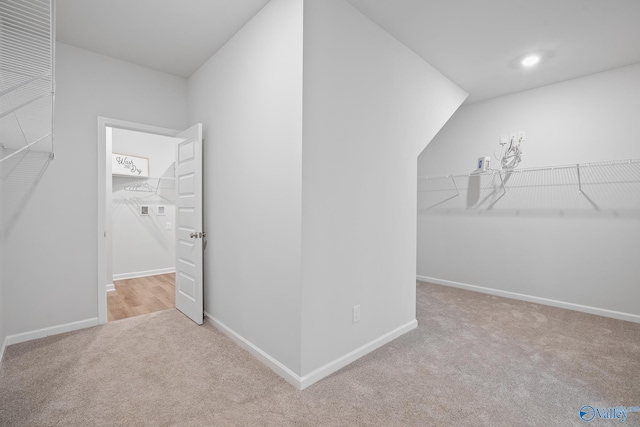 walk in closet featuring light carpet