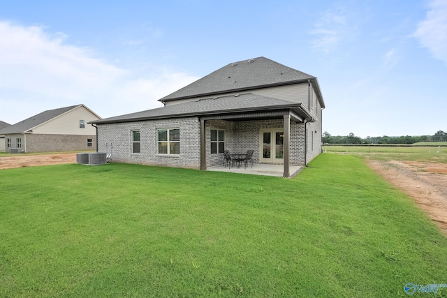 rear view of property with french doors, a yard, and a patio area