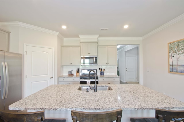 14267 Leadenhall Ln, Athens, AL 35613 - kitchen featuring appliances with stainless steel finishes, a sink, a breakfast bar, light stone counters, and crown molding