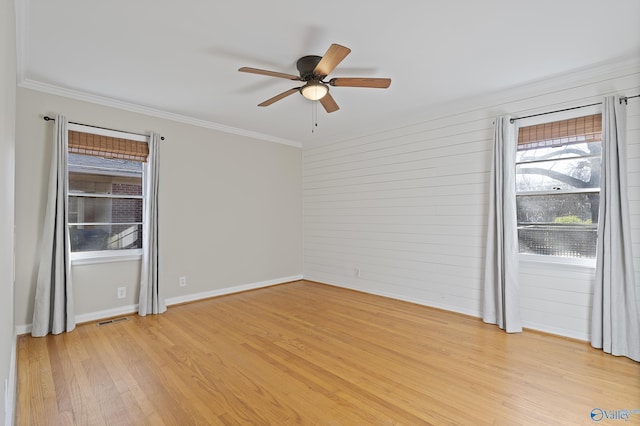 spare room with visible vents, light wood-style flooring, crown molding, and ceiling fan