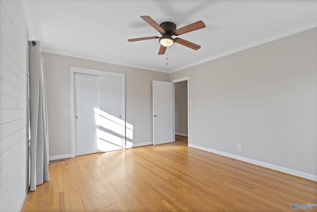 unfurnished bedroom featuring a closet, baseboards, light wood-style floors, and ornamental molding