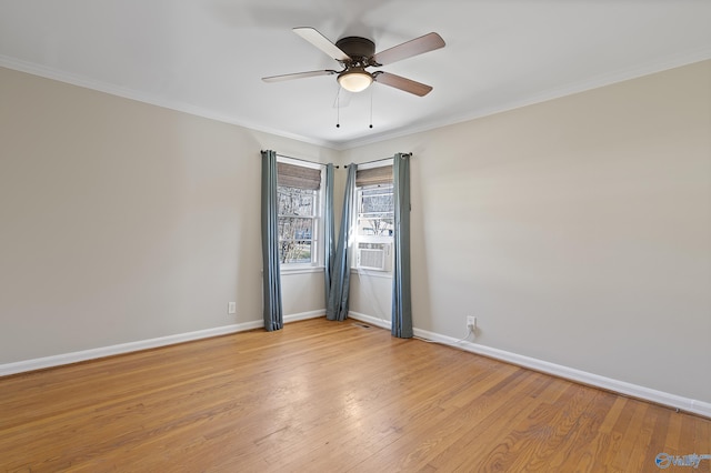 spare room featuring baseboards, light wood-style flooring, a ceiling fan, and ornamental molding