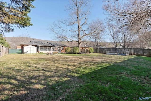 view of yard with a fenced backyard, a storage shed, and an outdoor structure