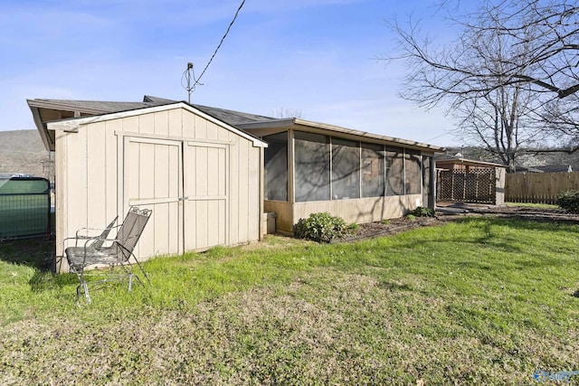 view of shed featuring fence and a sunroom