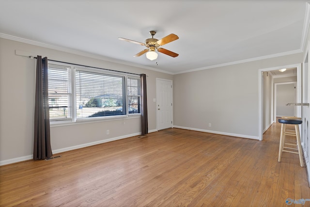 empty room with light wood-type flooring, baseboards, ceiling fan, and crown molding