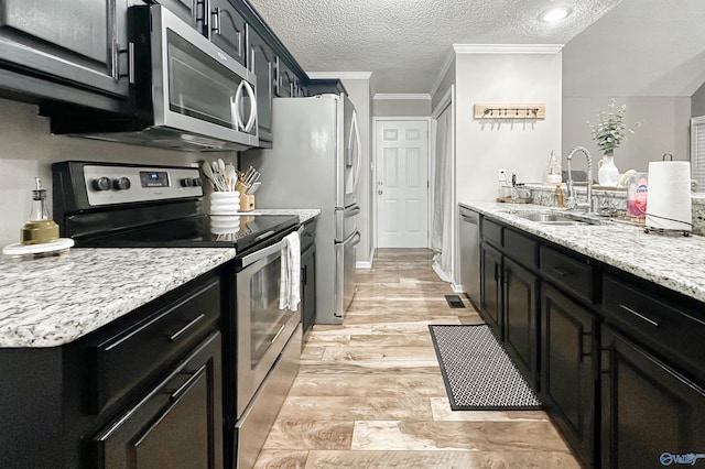 108 Mountain Home Rd, Trinity, AL 35673 - kitchen featuring stainless steel appliances, a sink, a textured ceiling, dark cabinetry, and light stone counters