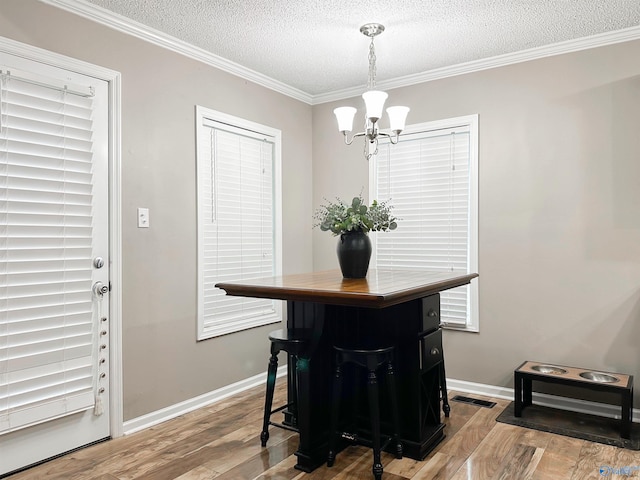 108 Mountain Home Rd, Trinity, AL 35673 - dining room with wood finished floors, a textured ceiling, a chandelier, ornamental molding, and baseboards