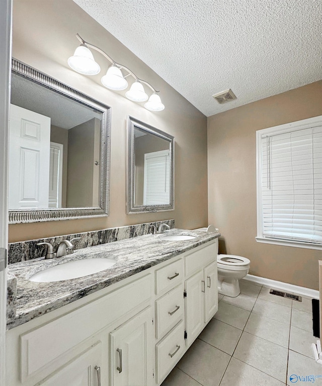 108 Mountain Home Rd, Trinity, AL 35673 - bathroom featuring toilet, tile patterned floors, double vanity, a textured ceiling, and baseboards