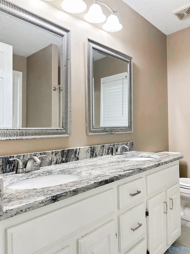 108 Mountain Home Rd, Trinity, AL 35673 - bathroom featuring toilet, a textured ceiling, and double vanity
