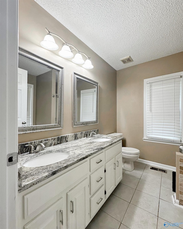 108 Mountain Home Rd, Trinity, AL 35673 - bathroom featuring toilet, double vanity, tile patterned flooring, a textured ceiling, and baseboards