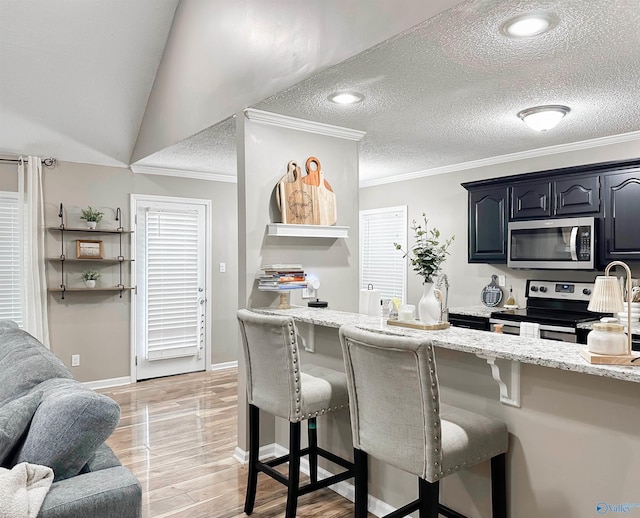 108 Mountain Home Rd, Trinity, AL 35673 - kitchen featuring stainless steel appliances, a breakfast bar area, light stone counters, ornamental molding, and a textured ceiling