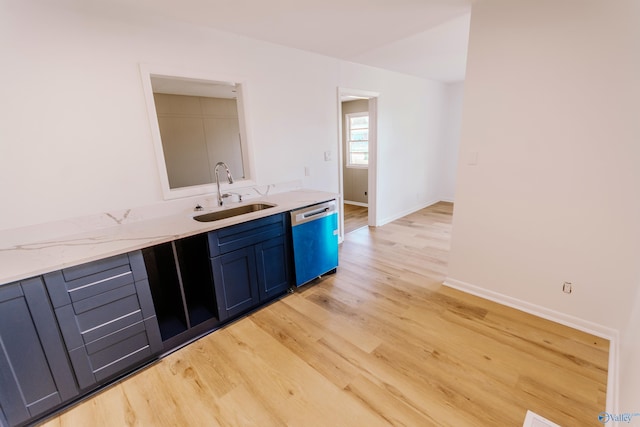 kitchen featuring stainless steel dishwasher, light stone countertops, sink, and light hardwood / wood-style flooring