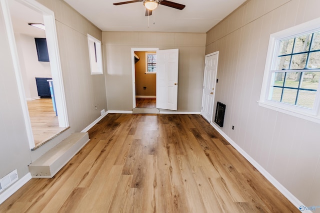 interior space featuring heating unit, wood-type flooring, and ceiling fan