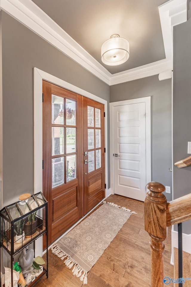 foyer entrance featuring crown molding, french doors, and wood finished floors