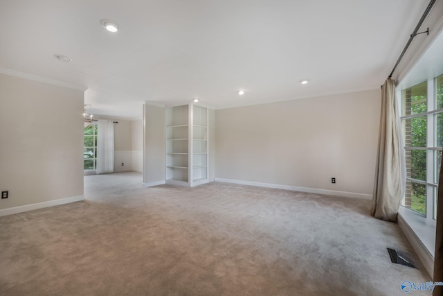 spare room with ornamental molding and light carpet