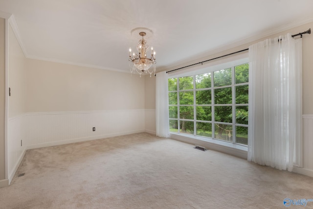 carpeted empty room with a notable chandelier and crown molding