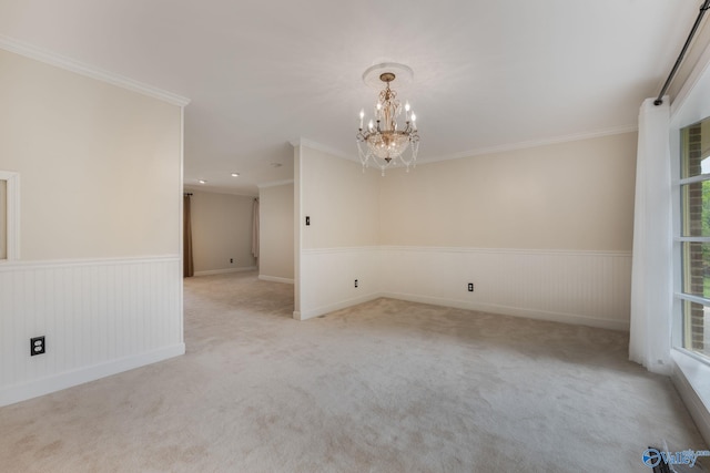 carpeted empty room with an inviting chandelier and ornamental molding