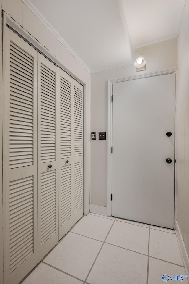 interior space with light tile patterned flooring and ornamental molding