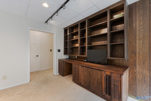 unfurnished office with a drop ceiling, light carpet, and track lighting