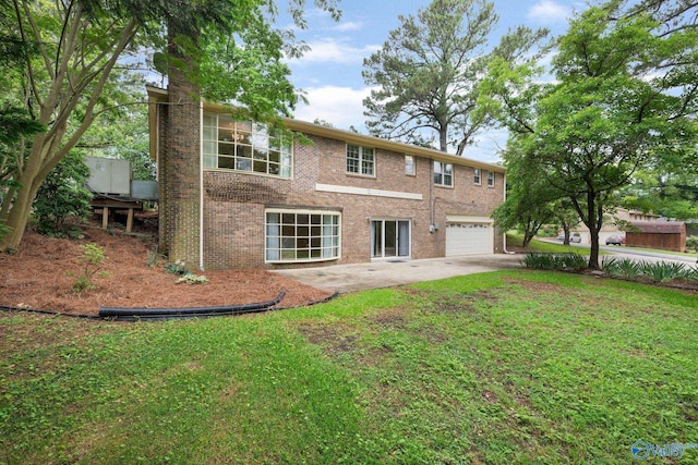 rear view of house with a garage and a yard