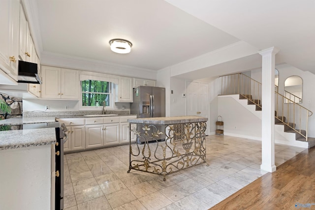 102 Fern Cv, Florence, AL 35634 - kitchen featuring stove, stainless steel fridge with ice dispenser, a sink, white cabinets, and crown molding