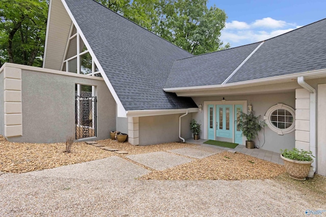 102 Fern Cv, Florence, AL 35634 - view of front of property featuring a shingled roof, stucco siding, and french doors