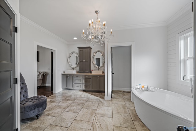 bathroom with crown molding, a washtub, vanity, and an inviting chandelier