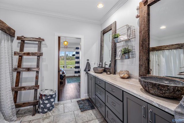 bathroom with tile patterned flooring, ornamental molding, and vanity