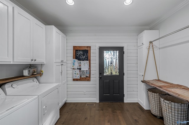 laundry room with wooden walls, cabinets, independent washer and dryer, crown molding, and dark wood-type flooring