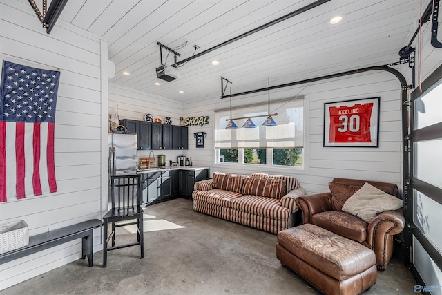 living room with sink, wood ceiling, and wood walls