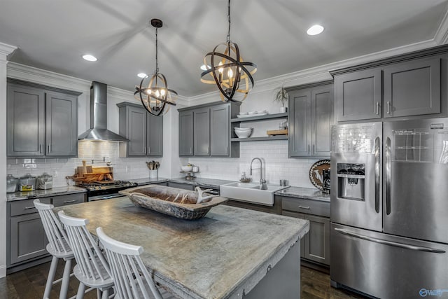 kitchen featuring stainless steel appliances, sink, gray cabinets, and wall chimney exhaust hood