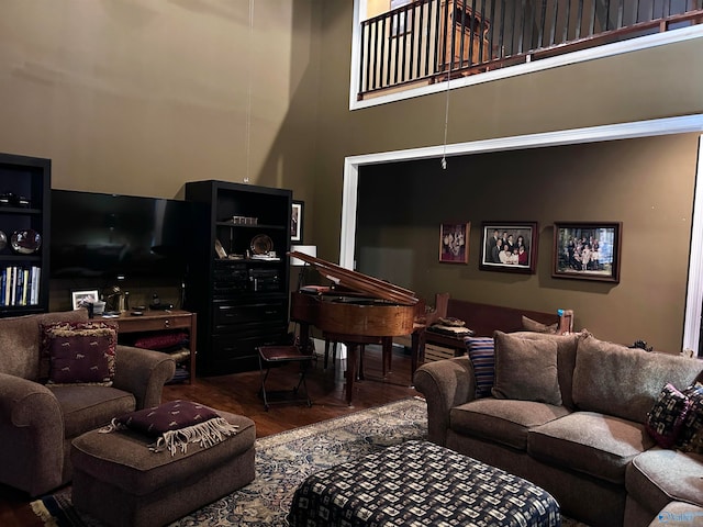 living room with a towering ceiling and dark hardwood / wood-style floors