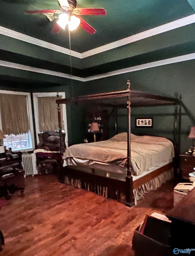 bedroom with ceiling fan, radiator heating unit, crown molding, and hardwood / wood-style flooring