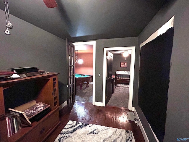 hallway featuring dark hardwood / wood-style flooring and vaulted ceiling