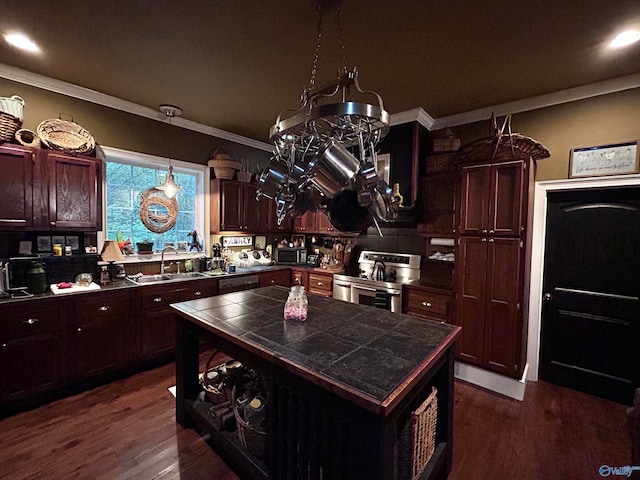 kitchen with tile countertops, dark wood-type flooring, ornamental molding, stainless steel range, and a kitchen island