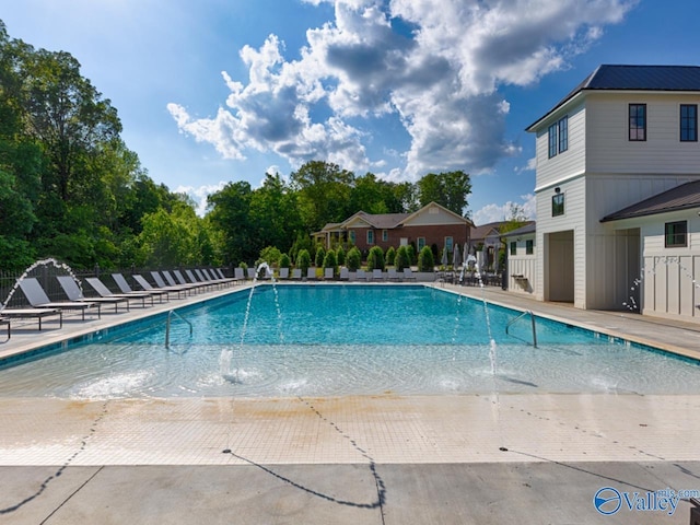 view of swimming pool with pool water feature and a patio area