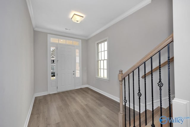 foyer featuring crown molding and light hardwood / wood-style flooring