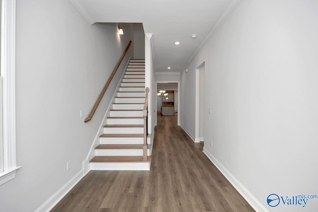 stairs featuring hardwood / wood-style flooring and ornamental molding