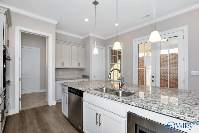 kitchen with hanging light fixtures, white cabinetry, appliances with stainless steel finishes, and sink