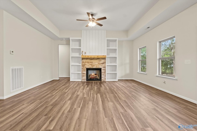 unfurnished living room with ceiling fan, hardwood / wood-style flooring, and a fireplace